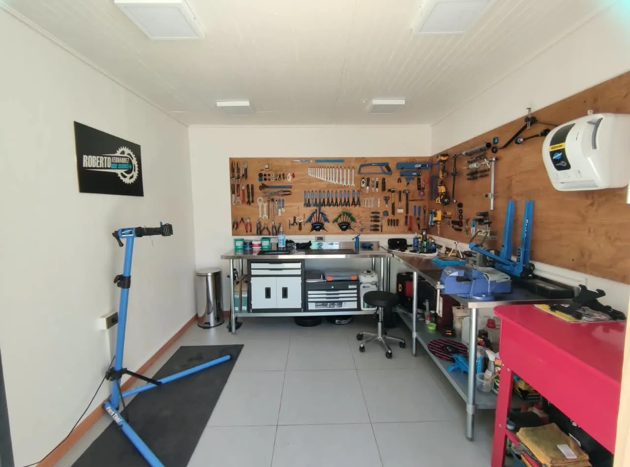 Interior del taller: pedestal de trabajo, mesones de acero y panel de herramientas